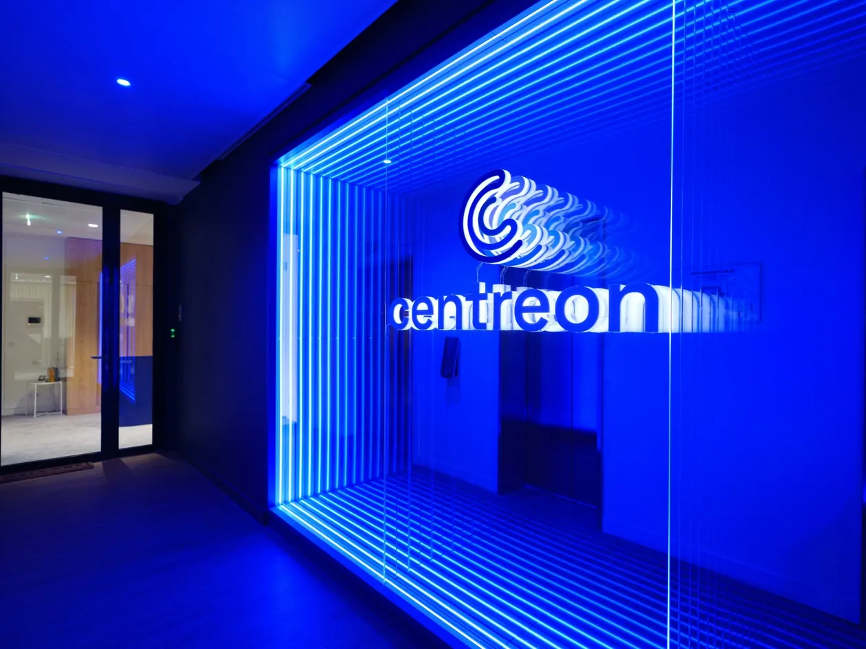 Eingang des Centreon-Büros in Paris mit blau beleuchtetem Centreon-Logo hinter einer Glaswand